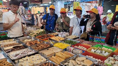 Foreign young farmers visit a vegetarian food supply store featuring soy products and a variety of processed agricultural goods.--view in new window
