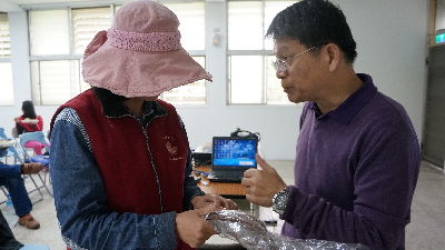 農民帶自己栽培的當歸植株向農改場中草藥專家張同吳副研究員詢問生長情形問題--將另開視窗看原圖