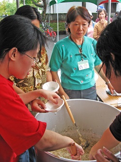 在吉野一號品嚐攤位旁忙進忙出(羅桂春為中間掛名牌者) 在吉野一號品嚐攤位旁忙進忙出(羅桂春為中間掛名牌者)
