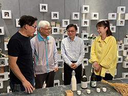 本場楊大吉場長(右二)向詹姆士(左一)介紹吉野1號現今的利用，包括釀製甘酒、清酒及蒸餾酒等