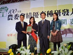 本場萱草團隊成員：蔡月夏(左二)、林學詩(右二，現為台東改良場 場長)以及林秀妹(右一)，接受農委會陳武雄主委(左一)授獎表揚及 鼓勵其育種優良貢獻